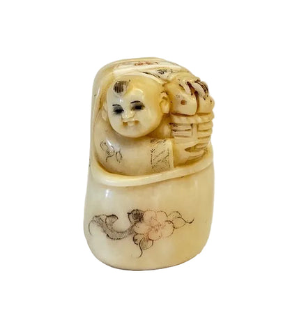 פסלון נטסקה (Netsuke) יפני עתיק: תינוק צוחק בעריסה | עצם מגולפת | חתום